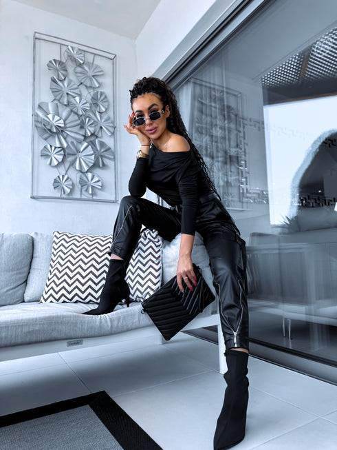 Black faux leather pants with zippers at the ends